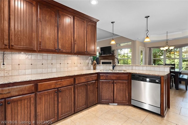 kitchen with sink, stainless steel dishwasher, a notable chandelier, kitchen peninsula, and pendant lighting