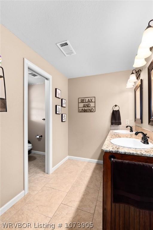 bathroom with tile patterned flooring, vanity, and toilet