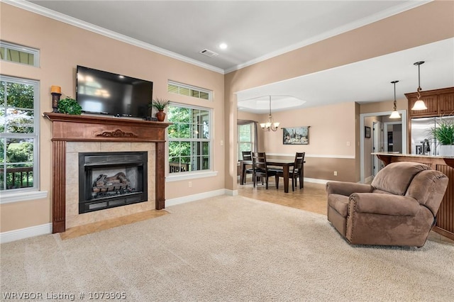 living room with light carpet, an inviting chandelier, ornamental molding, and a tiled fireplace