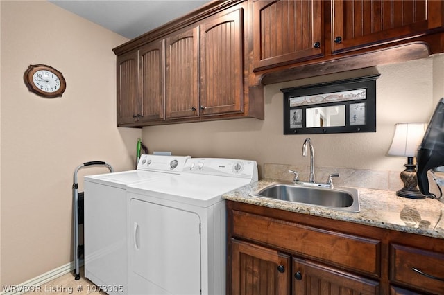 laundry room with washer and dryer, light tile patterned floors, cabinets, and sink