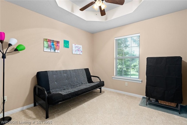 sitting room with carpet flooring, ceiling fan, and a tray ceiling