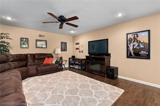 living room featuring ceiling fan and dark wood-type flooring