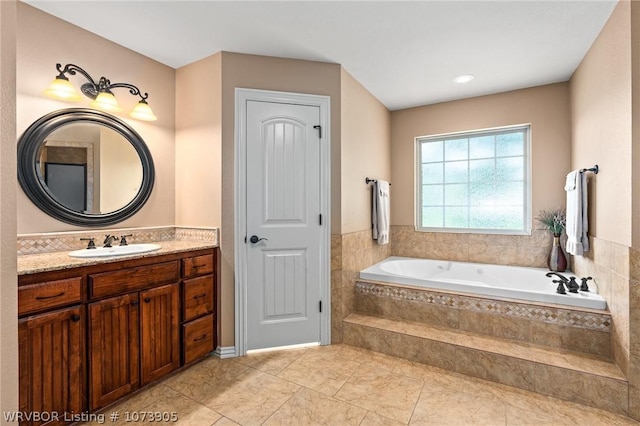 bathroom featuring vanity, a relaxing tiled tub, and tile patterned floors