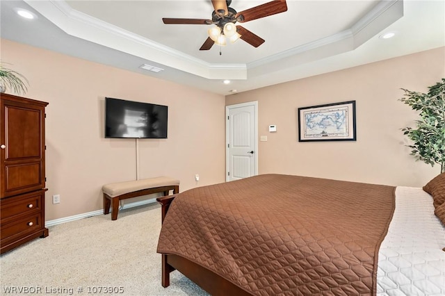 carpeted bedroom featuring a tray ceiling, ceiling fan, and ornamental molding