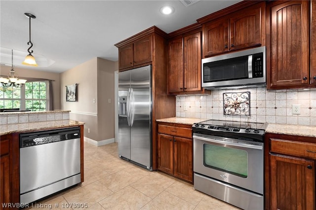 kitchen featuring light stone countertops, stainless steel appliances, and an inviting chandelier