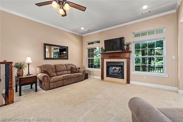 living room featuring carpet, a fireplace, ornamental molding, and ceiling fan