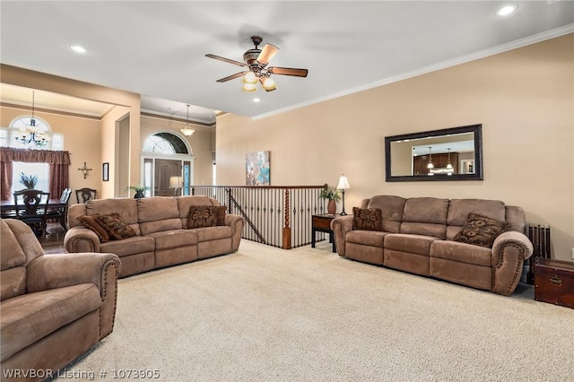 carpeted living room featuring ceiling fan with notable chandelier, radiator heating unit, and crown molding