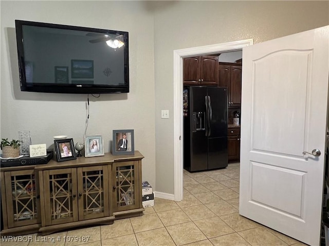 corridor with light tile patterned flooring and baseboards