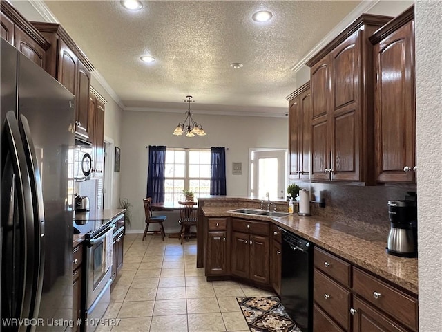 kitchen featuring dark brown cabinetry, black appliances, a sink, and hanging light fixtures