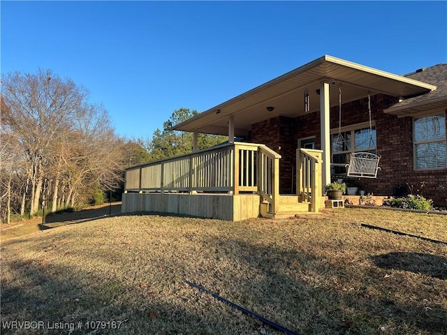 view of home's exterior with brick siding and a lawn