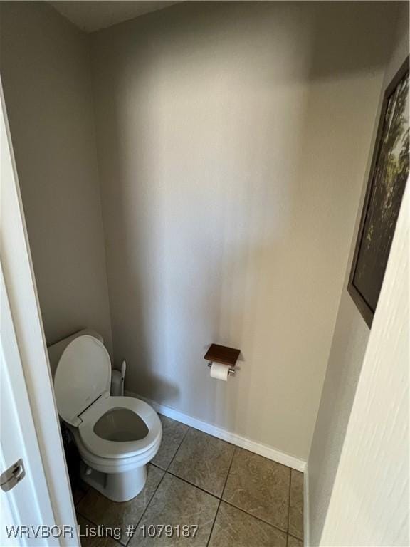 bathroom featuring tile patterned flooring, toilet, and baseboards