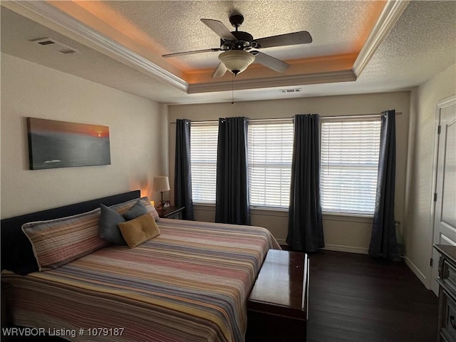 bedroom featuring a raised ceiling, visible vents, and a textured ceiling