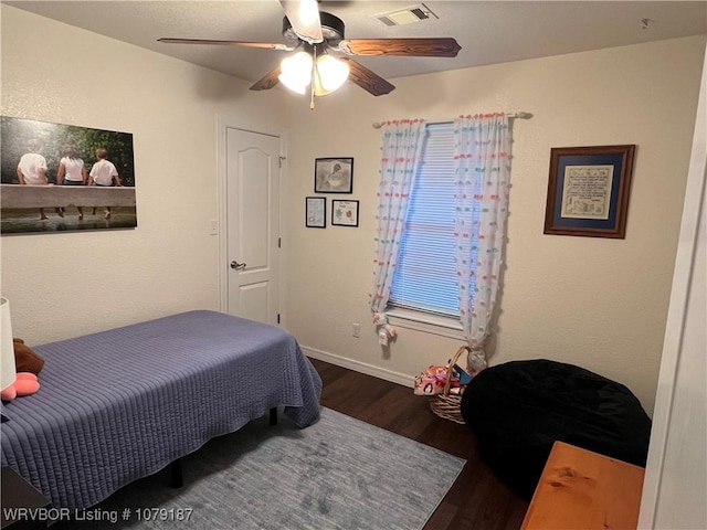 bedroom with dark wood-style floors, visible vents, baseboards, and a ceiling fan