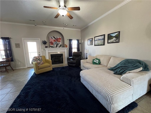 living area featuring plenty of natural light, visible vents, crown molding, and a fireplace with flush hearth