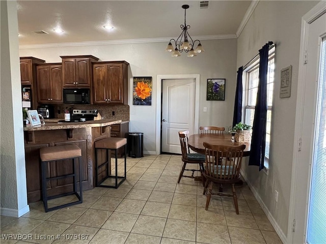 kitchen featuring black microwave, dark brown cabinetry, ornamental molding, backsplash, and a kitchen bar