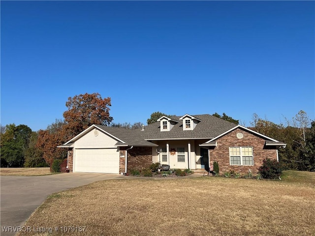 view of front facade with brick siding, roof with shingles, concrete driveway, an attached garage, and a front yard