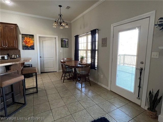 dining room featuring light tile patterned floors, visible vents, ornamental molding, a chandelier, and baseboards