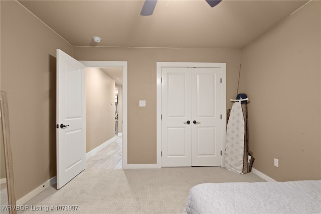 carpeted bedroom featuring ceiling fan and a closet