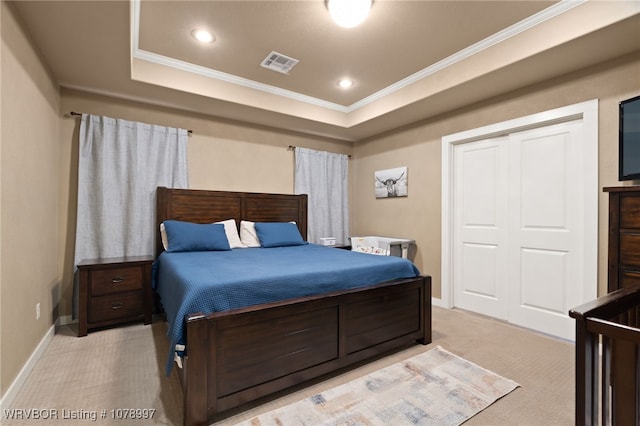 carpeted bedroom featuring a closet, crown molding, and a raised ceiling