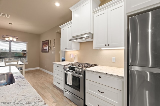 kitchen featuring decorative light fixtures, white cabinets, a chandelier, light stone counters, and stainless steel appliances