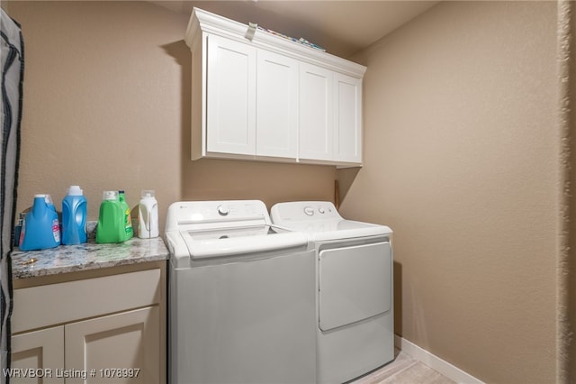 laundry area featuring cabinets and washing machine and clothes dryer