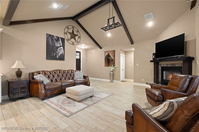 living room featuring a fireplace, high vaulted ceiling, beam ceiling, and light hardwood / wood-style floors