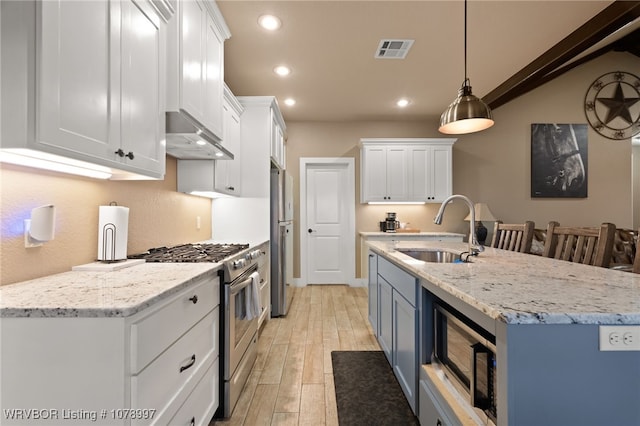 kitchen with sink, light hardwood / wood-style flooring, white cabinetry, hanging light fixtures, and stainless steel appliances