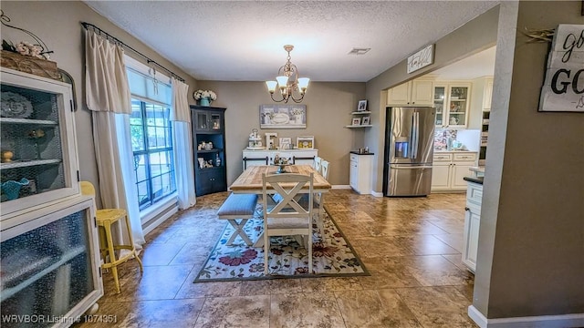 dining room with heating unit, a textured ceiling, and a chandelier