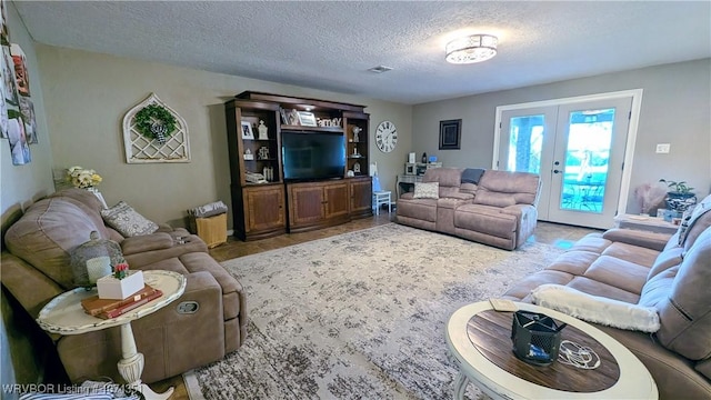 living room featuring a textured ceiling and french doors