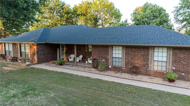 ranch-style house with a front yard and covered porch