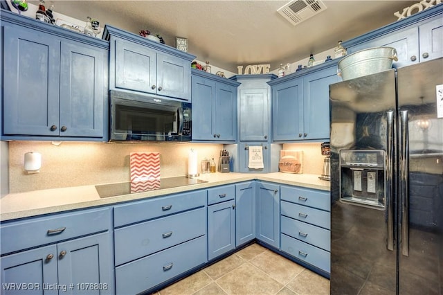 kitchen featuring light tile patterned flooring, blue cabinets, decorative backsplash, and black appliances