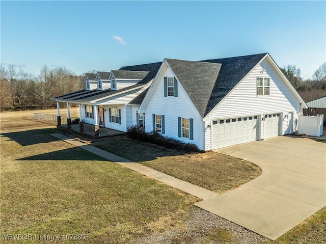 view of front of home featuring a garage, a front yard, and covered porch