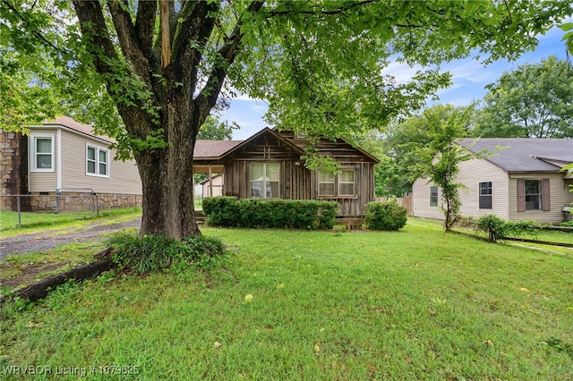 view of front facade featuring a front lawn and fence