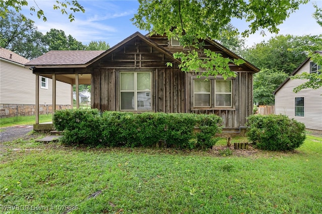 view of property exterior featuring a yard, board and batten siding, and fence