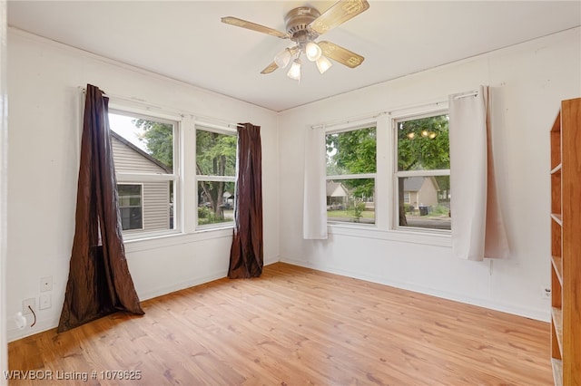 spare room featuring ceiling fan, baseboards, and wood finished floors