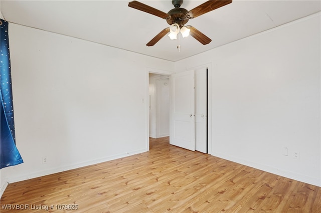 spare room featuring a ceiling fan, light wood-style floors, and baseboards