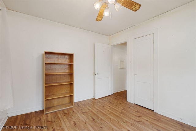 unfurnished bedroom with a closet, baseboards, and wood finished floors