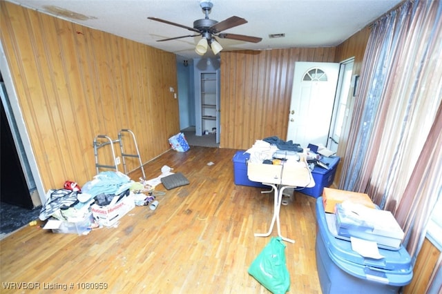 1126 S 2nd St, Stilwell, OK 74960 - unfurnished dining area featuring wooden walls, a ceiling fan, and wood finished floors