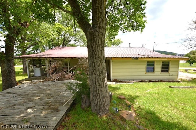 1126 S 2nd St, Stilwell, OK 74960 - back of property with a lawn, metal roof, and a wooden deck