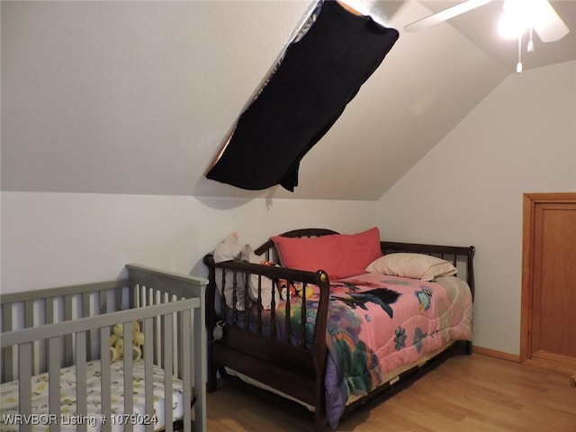 bedroom with vaulted ceiling and light wood-type flooring