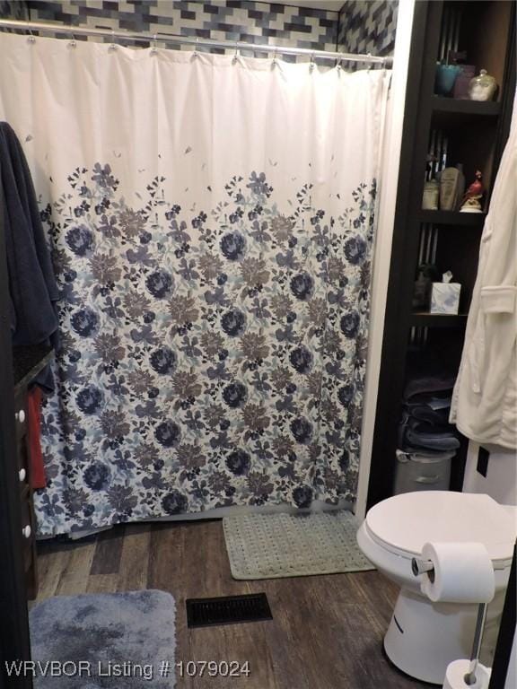 bathroom featuring a shower with curtain, wood-type flooring, and toilet