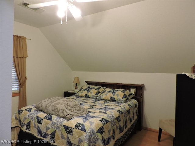 bedroom with vaulted ceiling and hardwood / wood-style floors