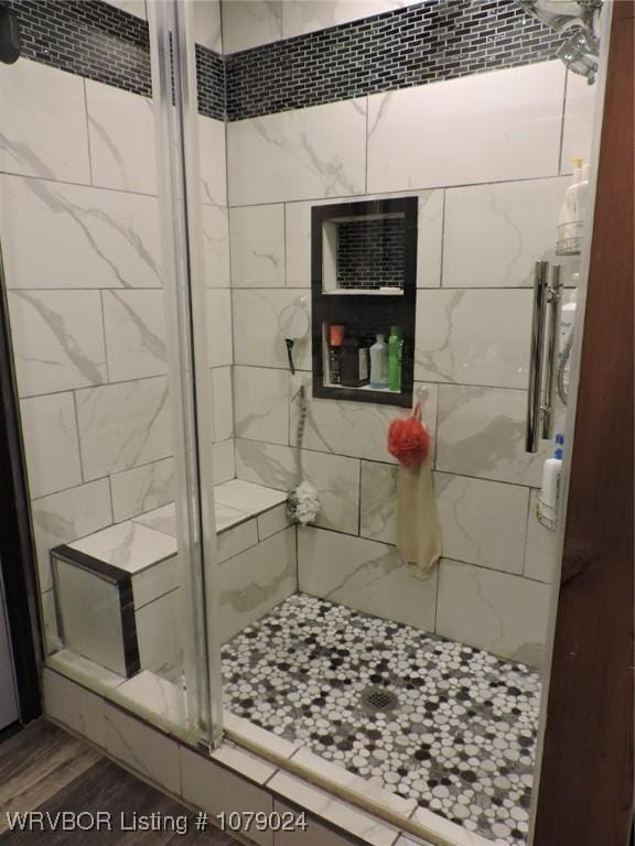 bathroom with an enclosed shower and hardwood / wood-style floors