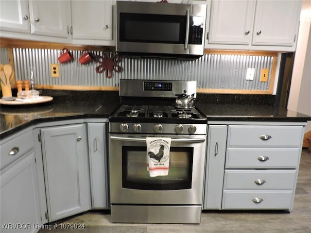 kitchen featuring appliances with stainless steel finishes, white cabinets, and light hardwood / wood-style floors