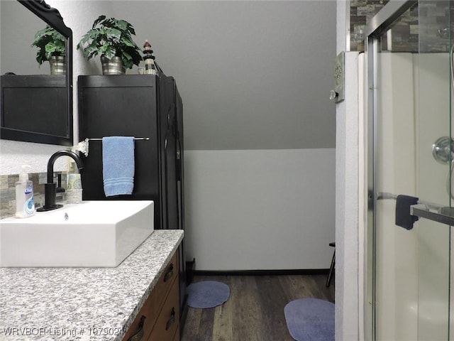 bathroom with vanity, lofted ceiling, hardwood / wood-style floors, and walk in shower