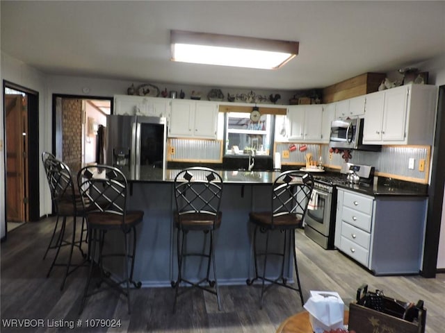 kitchen featuring wood-type flooring, appliances with stainless steel finishes, and white cabinets