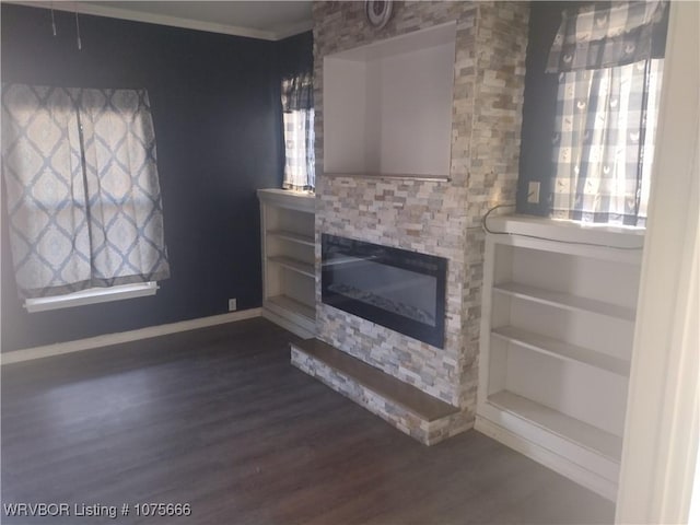 unfurnished living room featuring ornamental molding, dark wood-style flooring, a fireplace, and baseboards