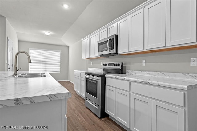 kitchen featuring baseboards, dark wood-type flooring, white cabinets, a sink, and stainless steel appliances