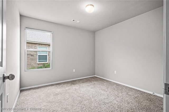spare room with carpet floors, baseboards, and visible vents