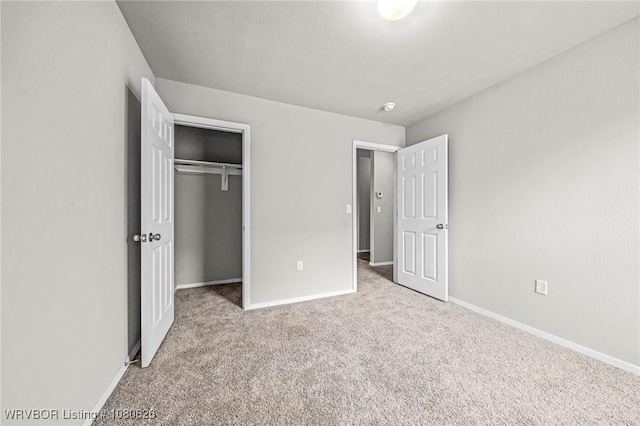 unfurnished bedroom with carpet floors, baseboards, and a closet